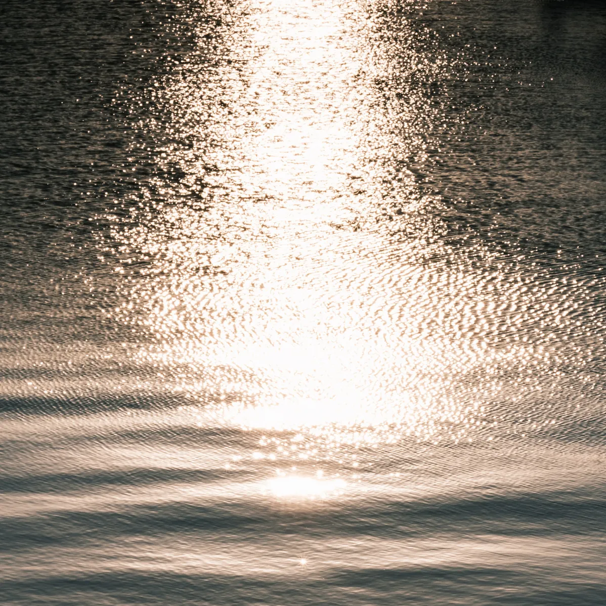 Sunlit, rippling water surface, representing the water element